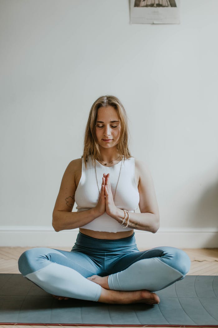 team-03 A serene image of a woman practicing meditation indoors, promoting mindfulness and wellbeing.
